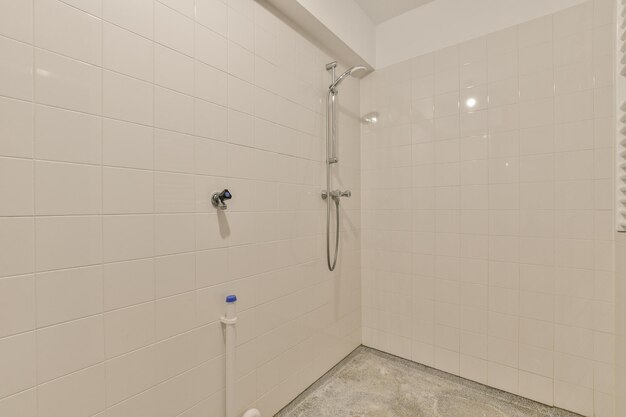 Une salle de bain carrelée de blanc avec une douche