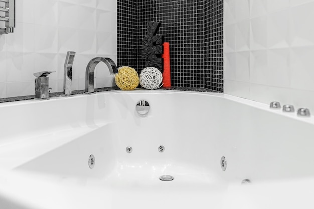 Salle de bain avec douche et grande baignoire jacuzzi aux murs contrastés blancs et noirs