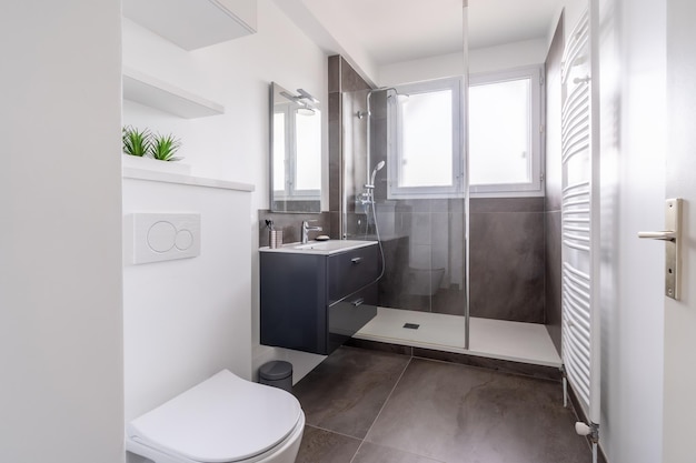 Salle de bain à la maison nouvel intérieur de salle de bain lumineux avec intérieur de meuble-lavabo en verre carrelé conçu en blanc et avec des carreaux noirs