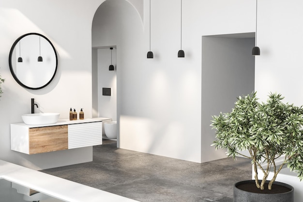 La salle de bain minimaliste, naturelle et sophistiquée, comprend un lavabo blanc, un miroir ovale, des toilettes, un bidet et une piscine.