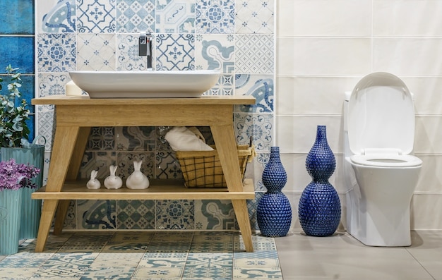 Salle de bain moderne et spacieuse avec des carreaux lumineux avec toilettes et lavabo.