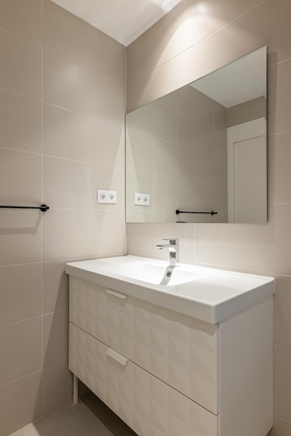 Salle de bain vide moderne avec meubles en carrelage beige et miroir rectangulaire