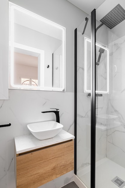 Salle de bains avec rénovation design moderne et robinetterie lavabo avec robinet noir murs de blanc