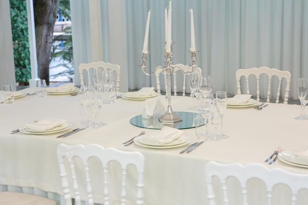 Salle de banquet vide prête à recevoir des invités sur la terrasse d'été. table de fête blanche