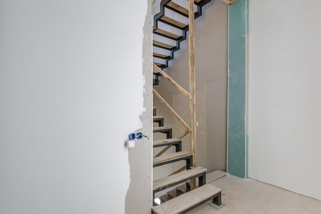 Salle blanche vide sans réparation et mobilier avec échafaudage avec escalier en bois