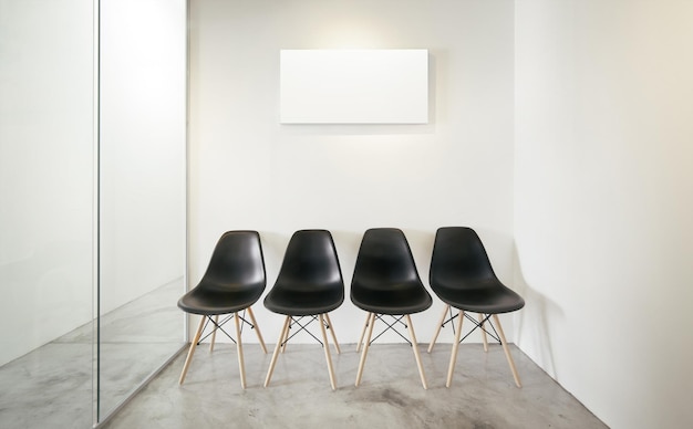 Salle de bureau vide Fenêtre en verre à gauche Impression sur toile blanche de style intérieur loft sur le mur blanc central Quatre chaises noires au sol en béton