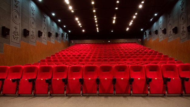 Une salle de cinéma vide avec des fauteuils en velours rouge. Cinéma vide.