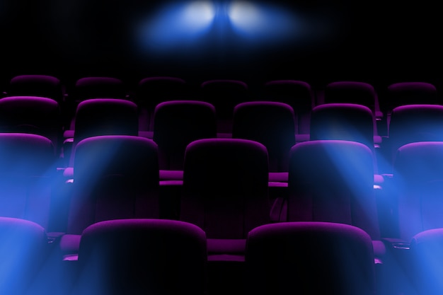 Salle de cinéma vide avec sièges violets avec rayons de lumière du projecteur