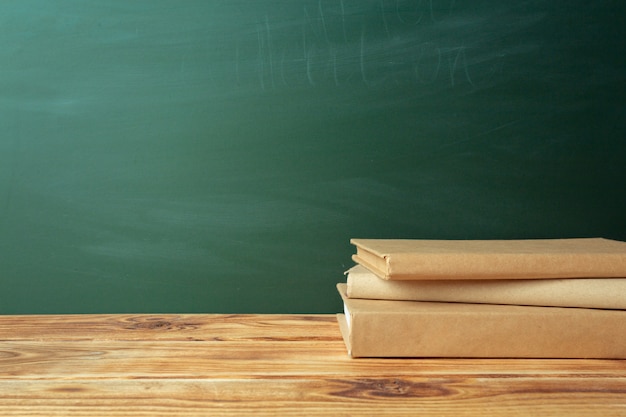 Salle de classe avec tableau noir, table en bois et livres