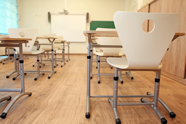 Salle de classe vide avec chaises et bureaux