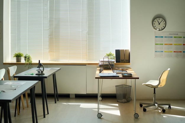 Salle de classe vide pendant la pause avec le lieu de travail de l'enseignant et deux bureaux