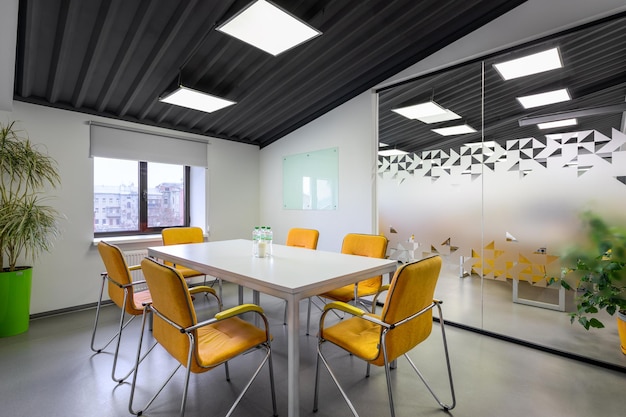 Une salle de conférence avec des chaises orange et un tableau blanc sur le mur dans l'espace de travail de réunion de bureau
