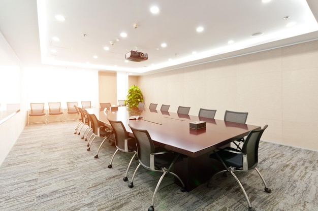 Salle de conférence moderne et spacieuse avec deux longues tables et chaises, parfaite pour les réunions d'entreprise