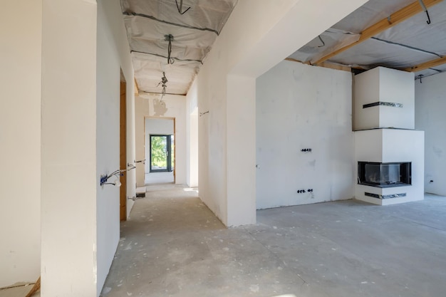 Salle de couloir vide non meublée avec un minimum de réparations préparatoires à l'intérieur avec des murs blancs et des cloisons sèches