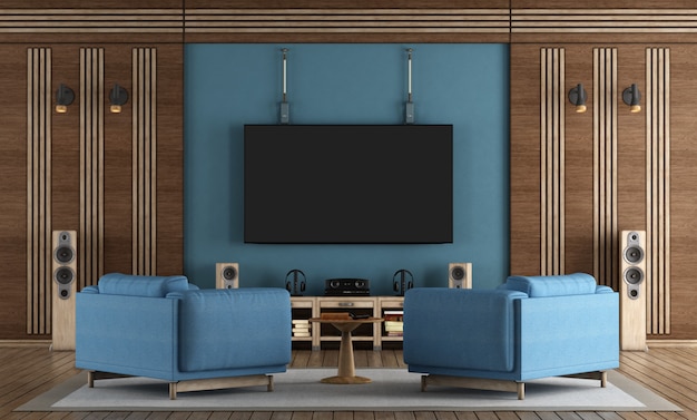 Salle de home cinéma avec télévision accrochée au mur bleu