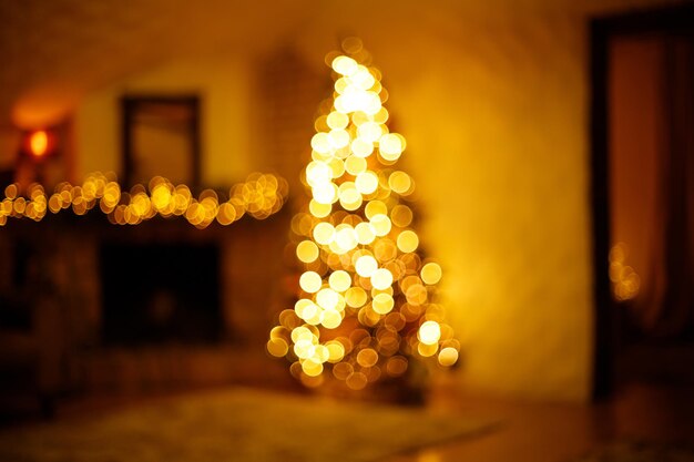 Salle de maison de noël chaleureuse avec sapin de noël et éclairage bokeh festif fond de vacances flou