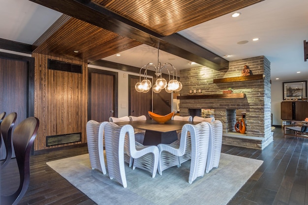 Une salle à manger avec une cheminée et un plafond en bois avec un grand lustre.