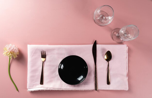 Salle à manger mise en place avec un ensemble d'assiettes vides placé avec un couteau et une fourchette prêt pour le menu alimentaire
