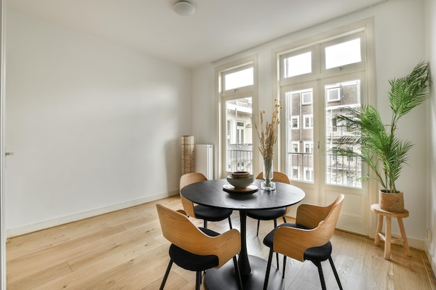 Une salle à manger avec une table et des chaises et des fenêtres