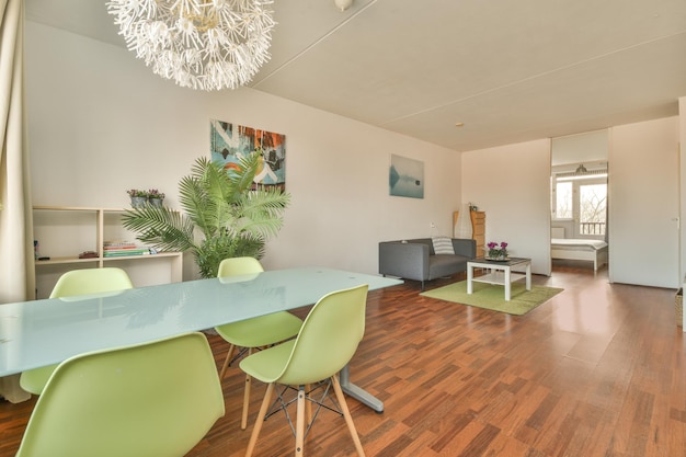 Photo une salle à manger avec une table en verre et des chaises vertes