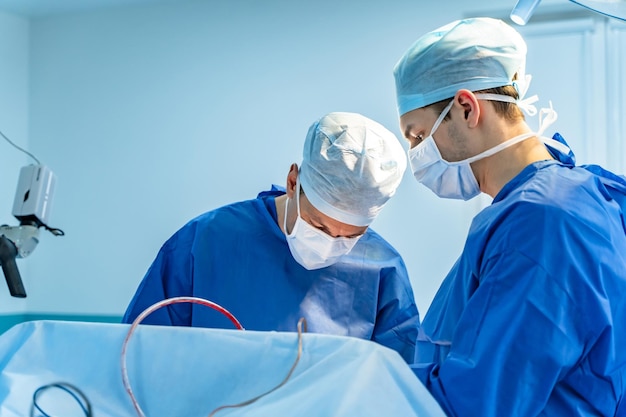 Salle d'opération avec chirurgie en cours Équipe médicale effectuant une opération chirurgicale dans une salle d'opération moderne et lumineuse