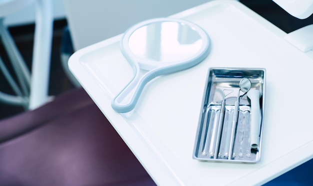 Photo une salle pleine de suppléments médicaux qui se composent d'un fauteuil dentaire, d'une lumière, d'un miroir, d'un explorateur et d'un polissoir dentaire