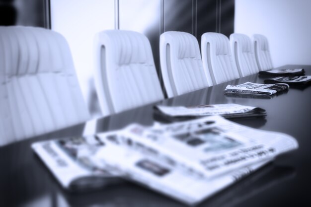 Salle de réunion avec des journaux sur la table