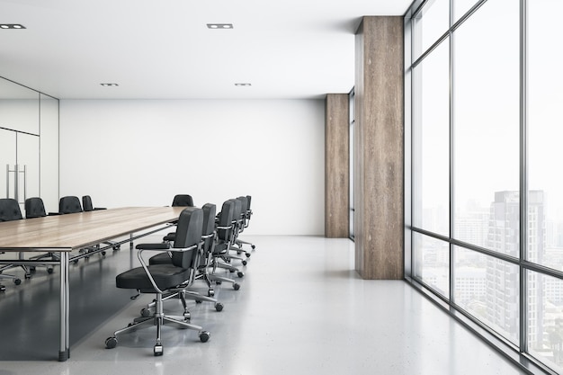 Salle de réunion spacieuse et lumineuse avec table de conférence en bois, chaises noires autour d'un sol brillant et d'une grande fenêtre