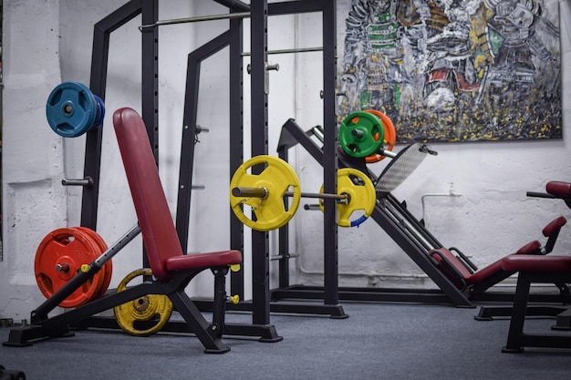 Une salle de sport avec un coussin rouge et des haltères jaunes