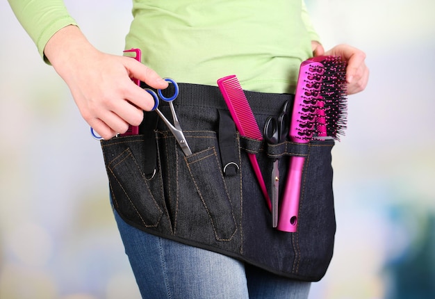 Salon de coiffure femme avec ceinture à outils sur fond clair