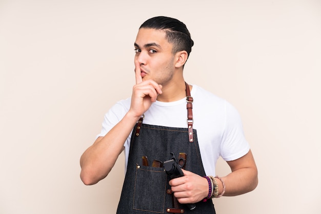 Salon De Coiffure Homme Dans Un Tablier Sur Mur Beige Faisant Le Geste De Silence