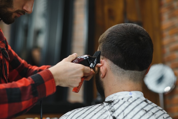 Salon de coiffure. Homme avec femme dans la chaise de barbier, coiffeur Barbershop coiffant ses cheveux