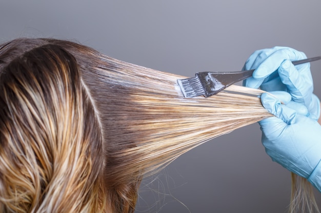 Salon de coiffure teignant les cheveux de sa cliente dans un salon