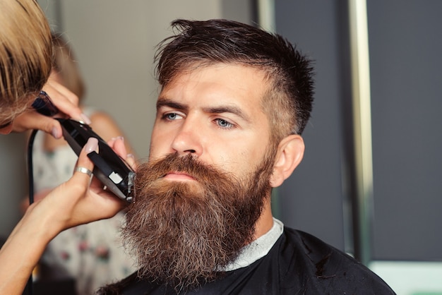 Salon de coiffure vintage, rasage. Homme en salon de coiffure. Rasoirs droits, salon de coiffure, barbe, lame. Coupe de cheveux pour hommes dans un salon de coiffure.