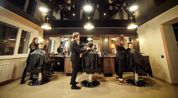 Salon Homme dans un fauteuil de coiffeur Le coiffeur sert le client dans le salon de coiffure Le concept de cosmétologie masculine