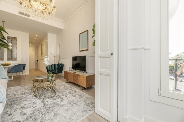 Salon d'une location de vacances avec moquette blanche et volets en bois laqué blanc cassé