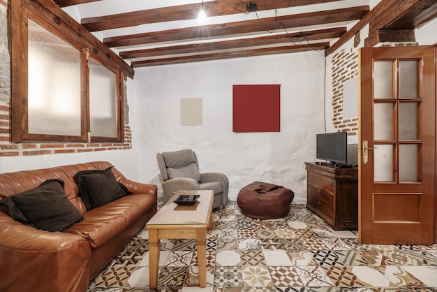 Un salon avec des murs en briques apparentes, des plafonds en grès hydraulique marron avec des poutres en bois et une double fenêtre de style rustique.