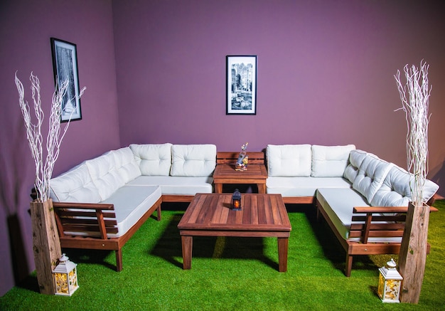 Un salon avec des murs violets et des canapés blancs et une table en bois.