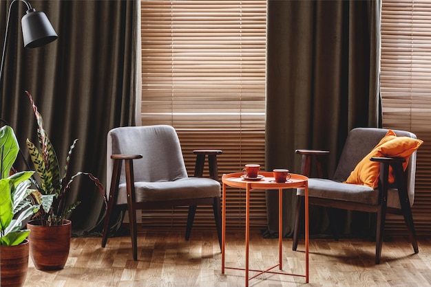 Un salon avec un rideau marron et une table avec un oreiller rouge dessus.