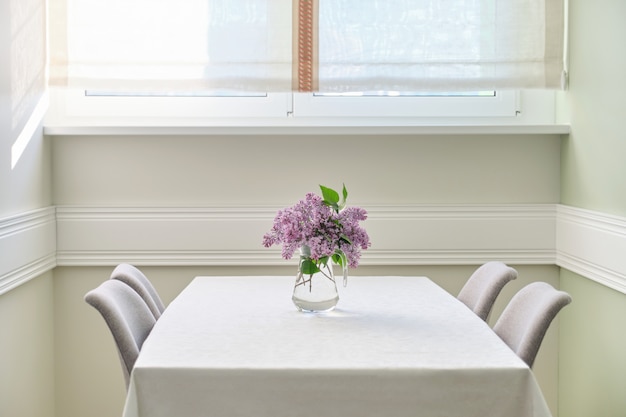 Photo salon salle à manger avec chaises, bouquet de lilas sur la table