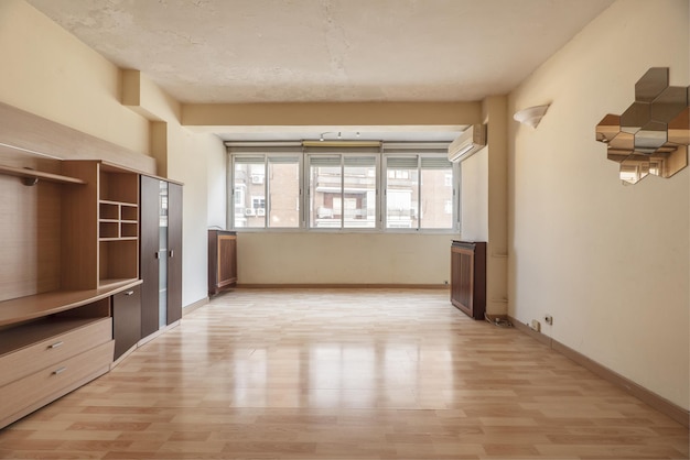 Salon spacieux dans un appartement avec une petite bibliothèque vide