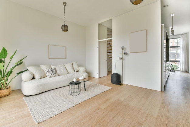 Un salon spacieux et lumineux avec un grand canapé blanc sur le tapis dans une maison confortable