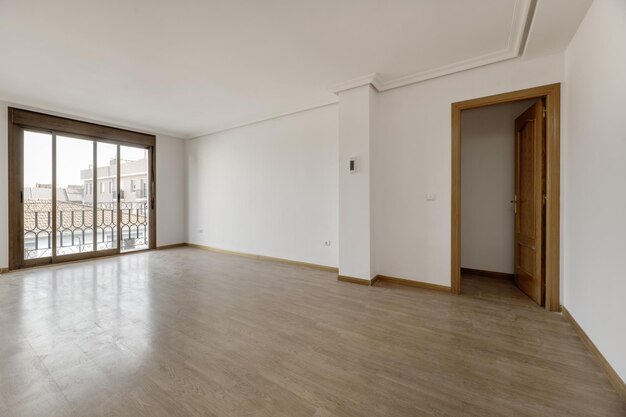 Salon vide d'une maison unifamiliale avec portes vers d'autres pièces parquet moulures en plâtre au plafond