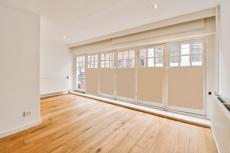 Photo un salon vide avec parquet et portes coulissantes de chaque côté de la pièce il y a un rad