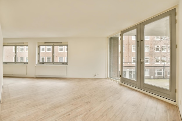 Photo un salon vide avec plancher en bois et des portes coulissantes en verre menant au balcon