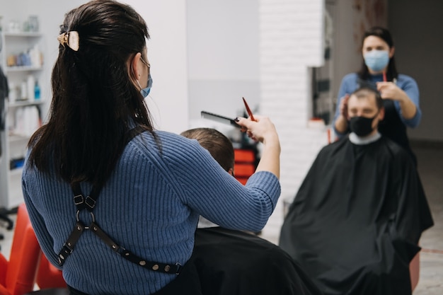 Les salons de coiffure des salons de coiffure ferment le deuxième coiffeur de verrouillage dans le pelage et le peignage du masque facial