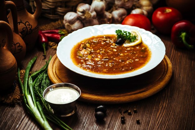 Saltwort à la viande de citron et d'olive sur une table en bois décorée de légumes frais et d'épices. Soupe traditionnelle avec différents types de viande