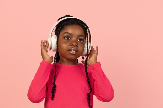 Salutation. Beau portrait de petite fille africaine isolé sur fond de studio rose avec fond. Modèle féminin élégant. Concept d'émotions humaines, expression faciale, ventes, publicité, mode, jeunesse.