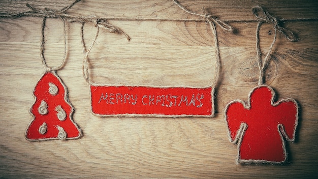 Salutations de Noël attachées à une corde sur un fond en bois. place pour le texte