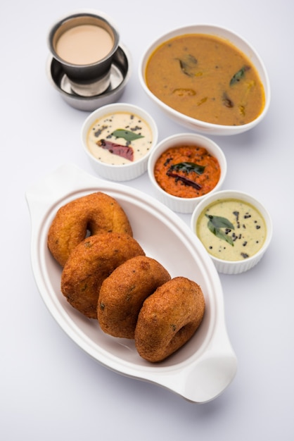 Sambar vada ou Medu Vada, une cuisine populaire du sud de l'Inde servie avec du chutney vert, rouge et noix de coco sur fond de mauvaise humeur. Mise au point sélective